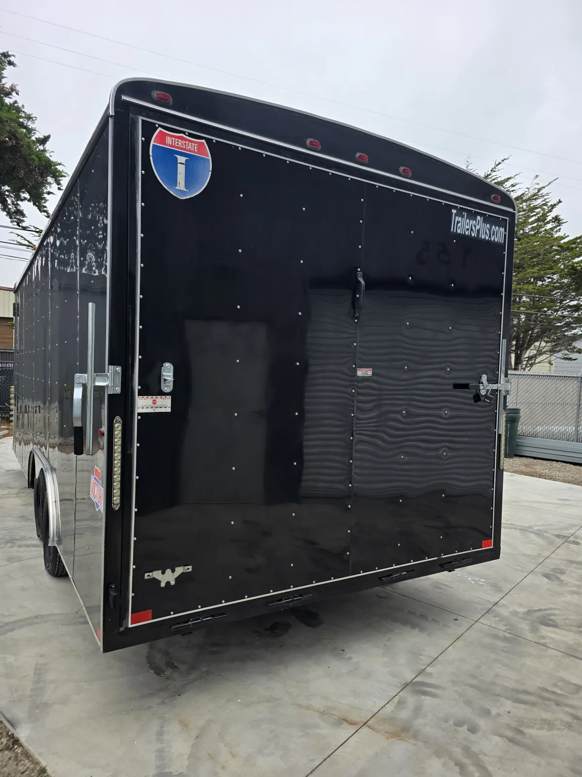 Black enclosed car-hauler trailer with rear ramp door photographed during a trailer VIN verification.